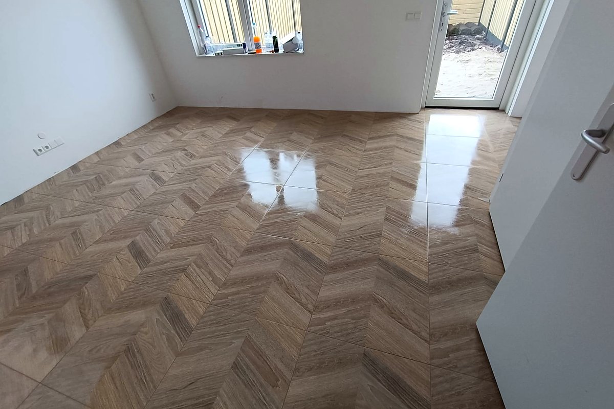 Lichte kamer met chevronvloer en uitzicht op de tuin
