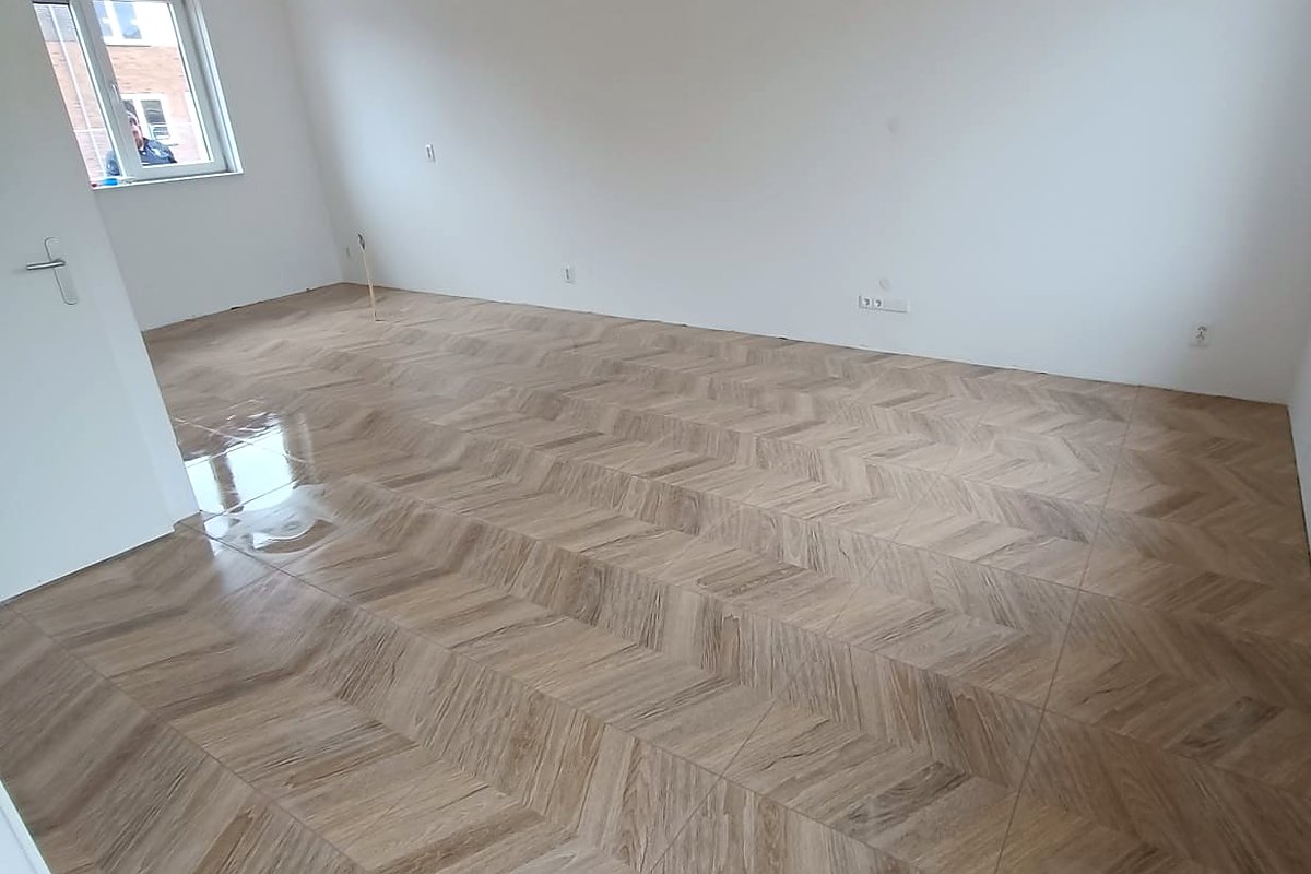 Lichte lege kamer met nieuw gelegde chevronvloer